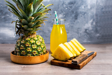 Wall Mural - pineapple and fresh pineapple slices with juice on the table