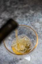 Close-Up Of A Glass Of White Wine Being Poured Into A Wine Glass