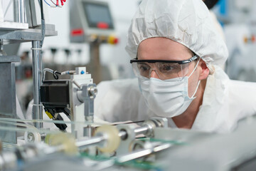 Engineer man wearing hygienic mask to protect coronavirus checking and inspection machine in production line at factory industry.