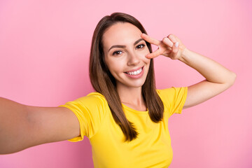 Canvas Print - Photo of charming cute young lady wear yellow t-shirt smiling recording video v-sign cover eye isolated pink color background