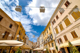 Fototapeta Uliczki - Summer view 2021 of the Alghero old town quarter and its narrow streets and the historic old town the Gulf of Alghero, Island of Sardinia, Italy, Europe