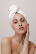 © Look! - Gorgeous young lady with pure skin, white silk towel on head and red nails looking into camera and posing isolated over light background
