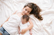 © ADDICTIVE STOCK - Smiling girl lying with newborn on bed