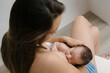 © ADDICTIVE STOCK - Anonymous mother breastfeeding baby in room at home