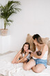 © ADDICTIVE STOCK - Mother with kids on sofa at home
