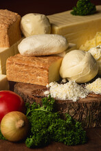 Assorted Whole And Grated Cheese On Wooden Stand