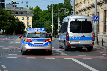 Wall Mural - Polska policja drogowa podczas pracy na drodze w mieście. Pojazdy policyjne. 