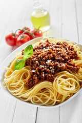 Wall Mural - Spaghetti bolognese with minced meat, cheese, and a basil leaf on the top