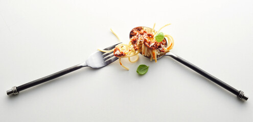 Poster - Fork and a spoon with spaghetti bolognese in the light background