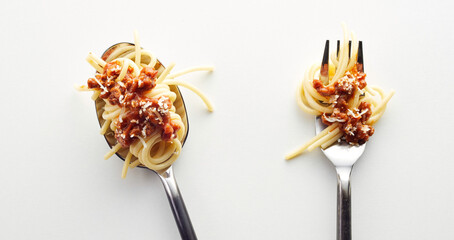 Wall Mural - Top view of spaghetti bolognese in a fork and spoonin the light background