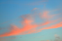 Beautiful Orange Clouds On Blue Sky Warm Summer Evening At Sunset, Backlit Sun. Excellent Calm Weather For Walking Sports, Outdoor Meditation. Water Vapor Condensation Products Suspended In Atmosphere