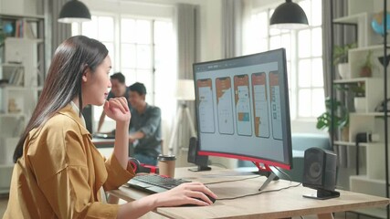 Asian Female Mobile Application Developer Thinking While Works With Graphics On Her Personal Computer In Office
