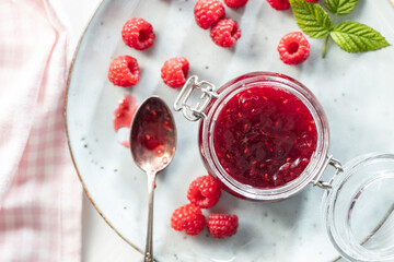 Poster - Red rasberries jam in jar and ripe raspberries.