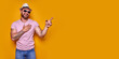 © zamuruev - Young man on vacation wearing shirt and summer hat over yellow background pointing finger with successful idea.