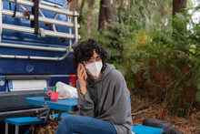 One Young Woman With A Mask Sit In Her Blue Classic Camper Van In The Forest