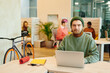 © pressmaster - Bearded male office manager in casualwear using laptop against colleagues