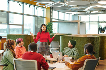 Canvas Print - Medium group of young intercultural designers looking at African businessman