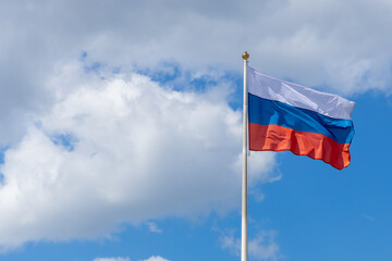 Wall Mural - Russian tricolor waving in the wind, frontal view. The flag of the Russian Federation flutters against a blue sky with clouds. National symbol of Russia. Copy space