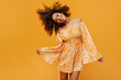© Look! - Positive woman in bright outfit playing her curly hair on isolated backdrop. Trendy girl in good mood smiling on yellow background..