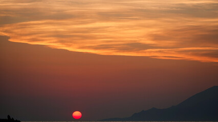 Wall Mural - Sun, beach, cliffs and mountain landscape at sunset