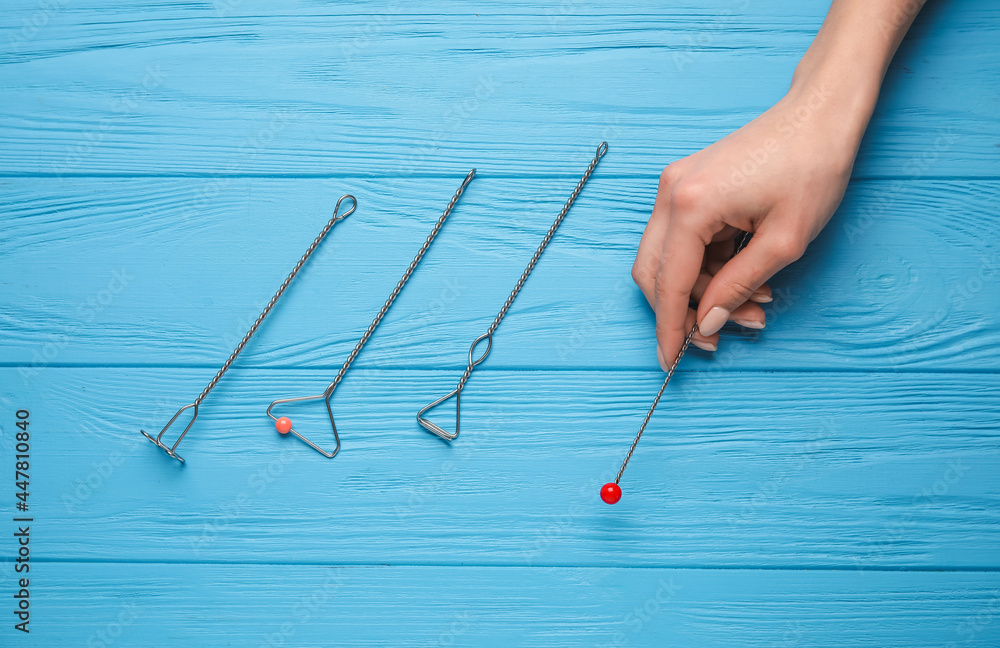 Female hand and logopedic tools for speech correction on color wooden background