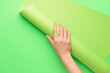 © Pixel-Shot - Female hand with paper roll on color background