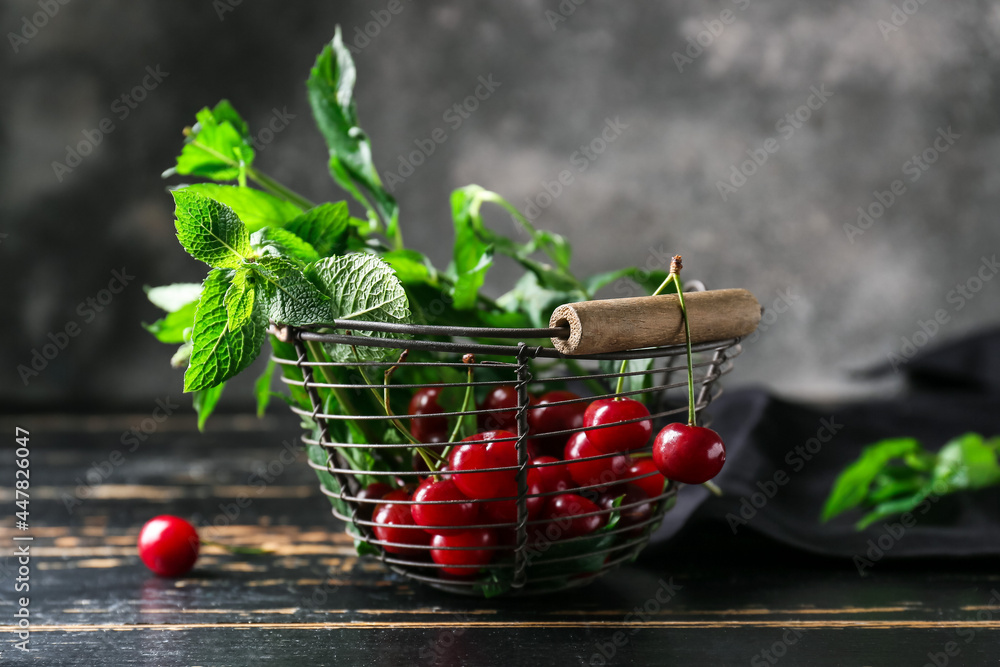 Basket with fresh cherries on dark wooden table, closeup