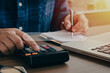 © Dee karen - business man sitting searching for people who pay annual taxes Along with calculating with a calculator in order to record it as evidence