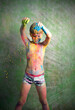 A multicolored portrait of a little boy with festive paints on his body.