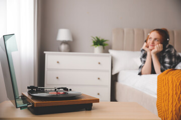 Poster - Young woman listening to music in bedroom, focus on turntable