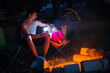 © Ольга Симонова - Dad and daughter sit at night by the fire in the open air in the summer in nature. Family camping trip, gatherings around the campfire. Father's Day, barbecue. Camping lantern and tent