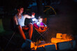 © Ольга Симонова - Dad and daughter sit at night by the fire in the open air in the summer in nature. Family camping trip, gatherings around the campfire. Father's Day, barbecue. Camping lantern and tent
