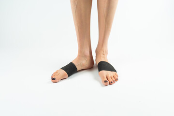  stabilizing orthosis for the correction of the big toe on the woman legs when hallux valgus, 2 legs, close-up isolated, white background