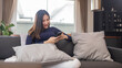 © snowing12 - Work from home concept a young businesswoman sitting on a cozy sofa using her mobile phone chatting with the customers