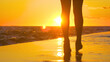SILHOUETTE: Female tourist goes for a stroll along the idyllic shore at sunset.