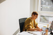 © Jacob Lund - Woman working at her office desk