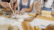 © Bangkok Click Studio - Hands of woman adult and little girls mixing flour on board to make bakery