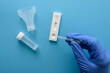 Hand in protective glove making antigen covid test with pipette and saliva