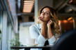 © BullRun - Casual dressed hipster girl with curly hair pondering on interesting ideas during leisure pastime in cafe interior, young Caucasian woman thinking about weekend spending resting in coffee shop
