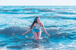 © ARVD73 - Young woman playing in the sea.woman make in sea water splash.Cheerful young woman having fun on the summer beach.