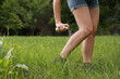 © New Africa - Woman applying insect repellent onto leg in park, closeup. Tick bites prevention