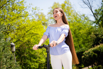 Poster - Portrait of attractive cheerful girl riding scooter spending free time having fun good mood rental at downtown outdoors