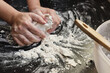 Close up view of woman's hands mixing dough on a table at home