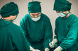 © butsaya33 - Asian Medical Team Performing Surgical Operation in Modern Operating Room. Doctors and Nurse in green uniform concentrate working in the hospital
