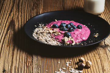 Wall Mural - Blueberry breakfast smoothie bowl. Fresh berries, rolled oats, toasted hazelnut and kefir in glass