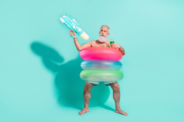 Sticker - Photo of cool serious man naked torso standing inside circles drinking cocktail shooting gun isolated turquoise color background