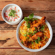 Traditional Hyderabadi Chicken dhum Biryani made of Basmati rice cooked with masala spices, served with raita, selective focus