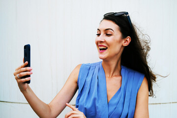 Portrait of pretty brunette wearing stylish blue top. Beautiful caucasian European female