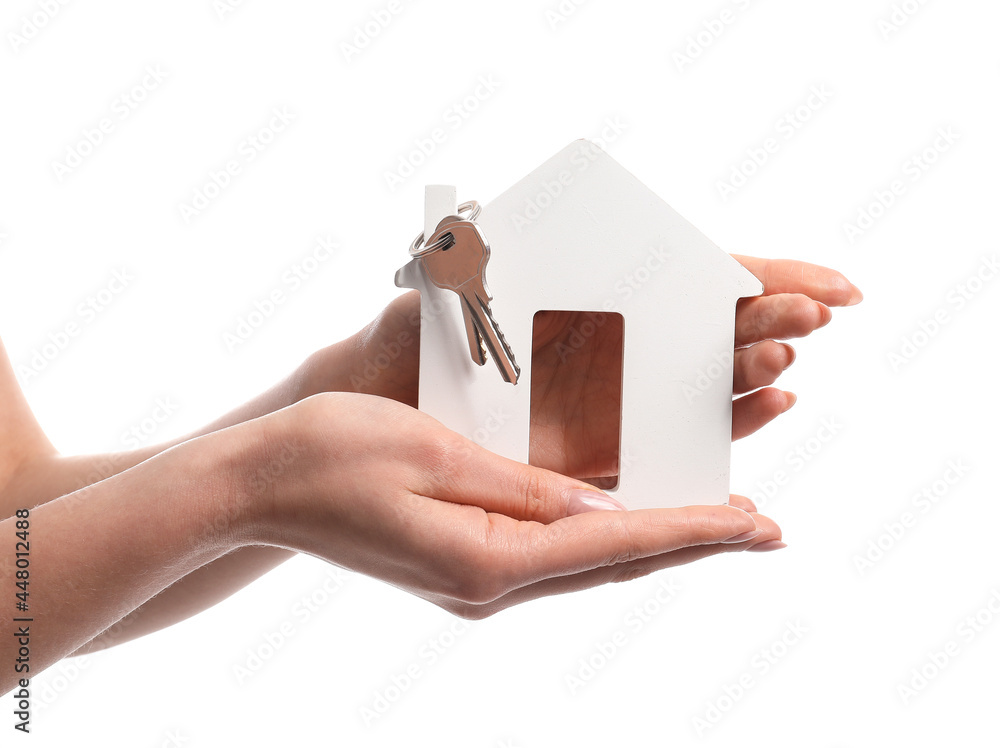 Female hand and key with house figure on white background