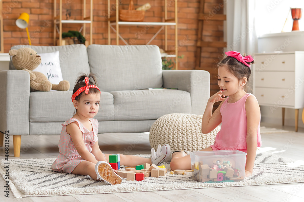 Cute little sisters playing at home